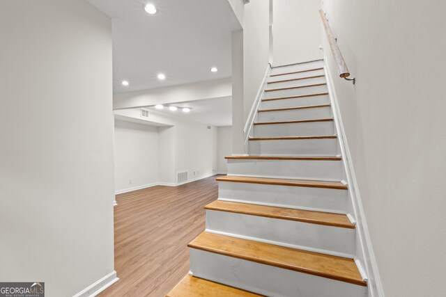 stairs featuring hardwood / wood-style floors