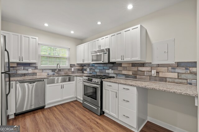 kitchen featuring stainless steel appliances, dark hardwood / wood-style floors, sink, and white cabinetry