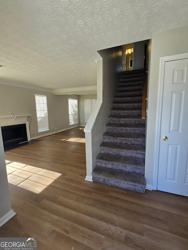 staircase featuring a textured ceiling and hardwood / wood-style flooring