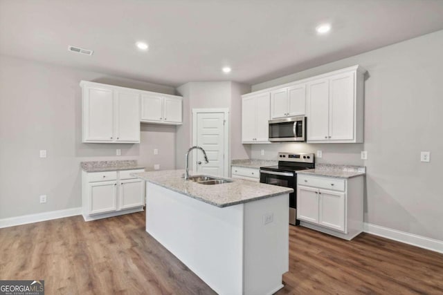 kitchen with appliances with stainless steel finishes, a kitchen island with sink, white cabinetry, and sink