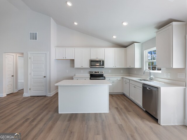 kitchen with a center island, sink, light hardwood / wood-style flooring, appliances with stainless steel finishes, and white cabinetry