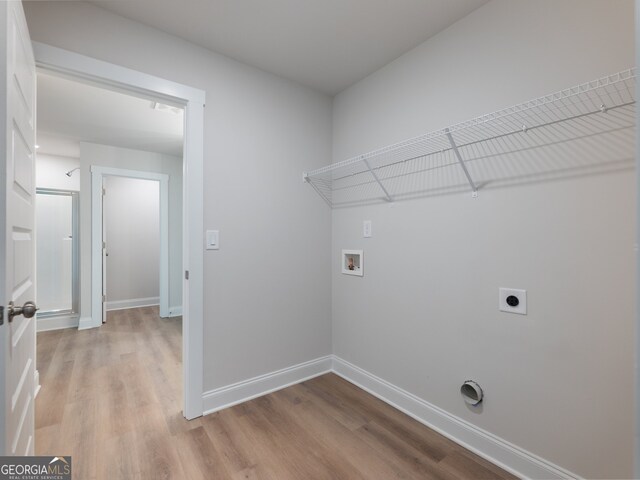 clothes washing area with hookup for an electric dryer, light wood-type flooring, and hookup for a washing machine