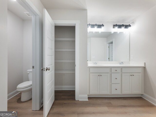 bathroom with vanity, hardwood / wood-style flooring, and toilet