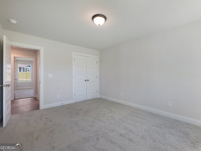 unfurnished bedroom featuring carpet floors and a closet