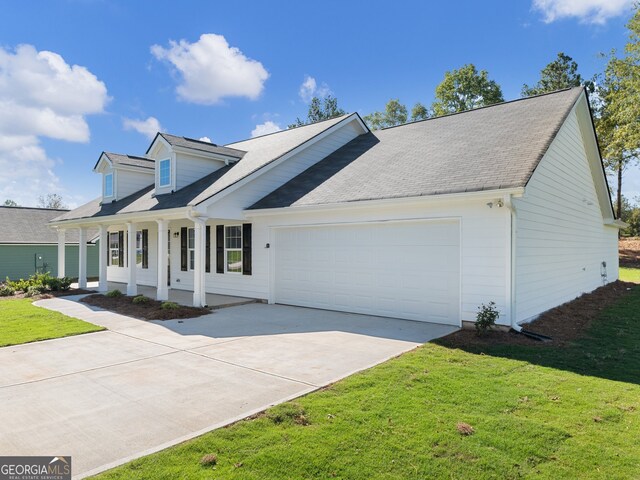 new england style home featuring a front lawn, covered porch, and a garage