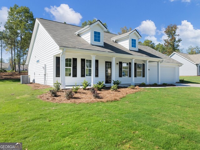 cape cod home featuring central air condition unit, covered porch, a front yard, and a garage