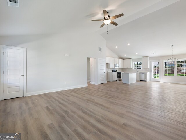 unfurnished living room with ceiling fan, high vaulted ceiling, and light hardwood / wood-style flooring