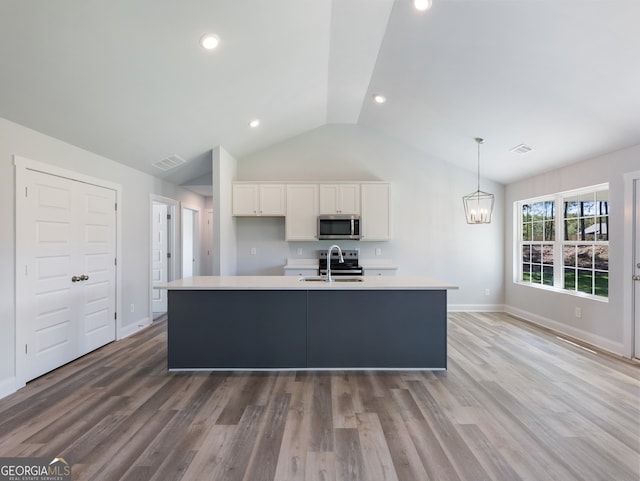 kitchen with white cabinetry, an island with sink, wood-type flooring, and appliances with stainless steel finishes