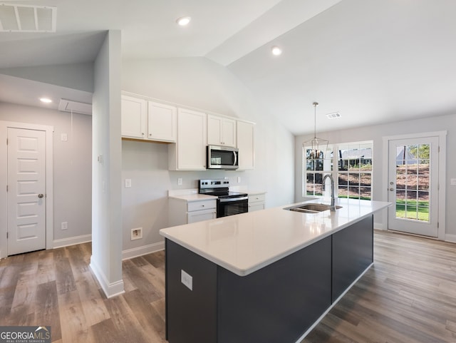 kitchen featuring a center island with sink, white cabinets, vaulted ceiling, and appliances with stainless steel finishes