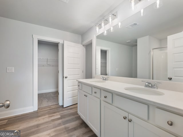 bathroom with hardwood / wood-style flooring, vanity, and a shower