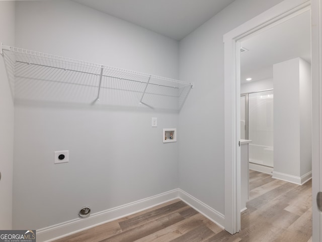 clothes washing area with hookup for an electric dryer, light wood-type flooring, and hookup for a washing machine