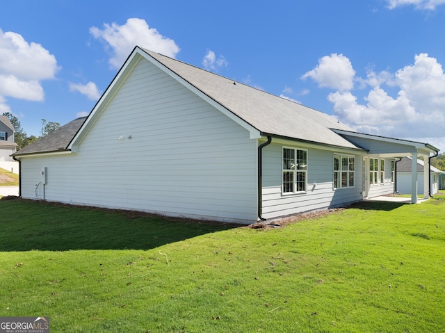 rear view of house featuring a yard