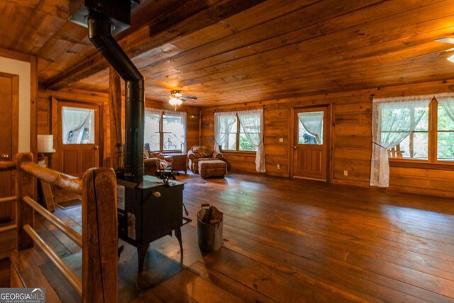 living room with wooden ceiling, wood walls, ceiling fan, and dark hardwood / wood-style floors