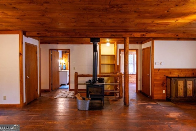 living room featuring wooden ceiling, dark hardwood / wood-style floors, and a wood stove