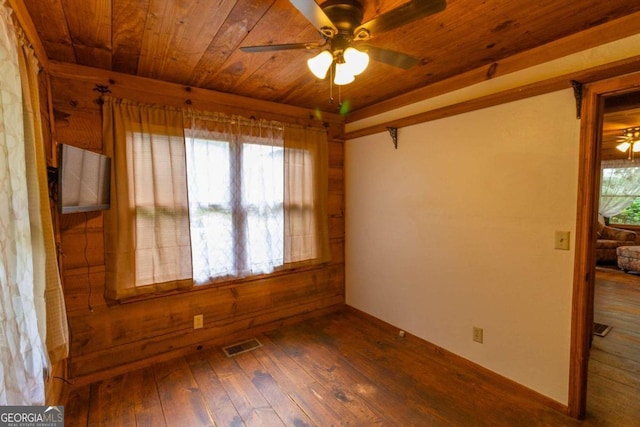 empty room with ceiling fan, hardwood / wood-style floors, and a healthy amount of sunlight