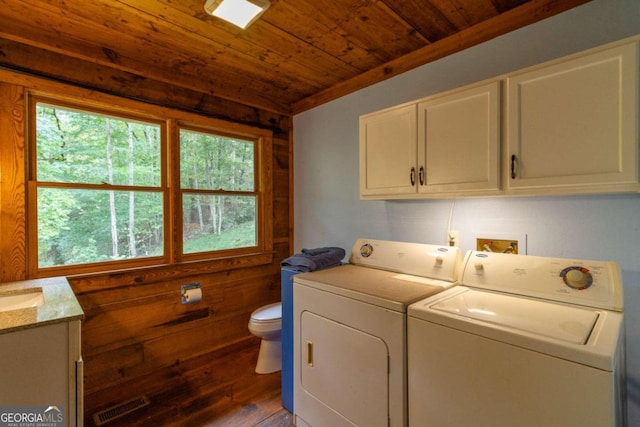 washroom with wood ceiling, wood walls, dark hardwood / wood-style floors, and washing machine and clothes dryer