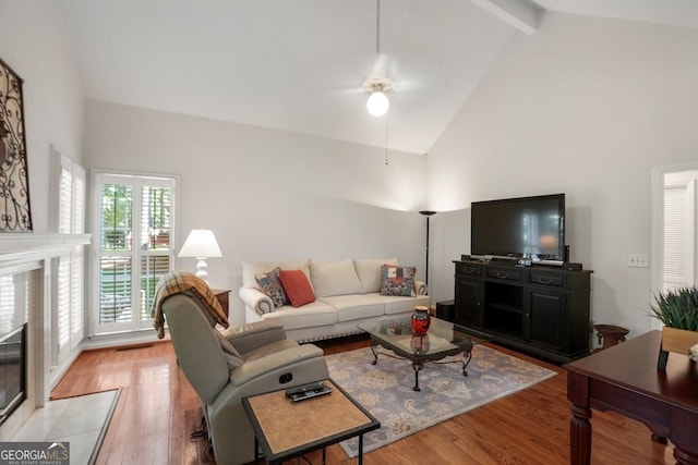 living room featuring high vaulted ceiling, beam ceiling, light wood-type flooring, and ceiling fan