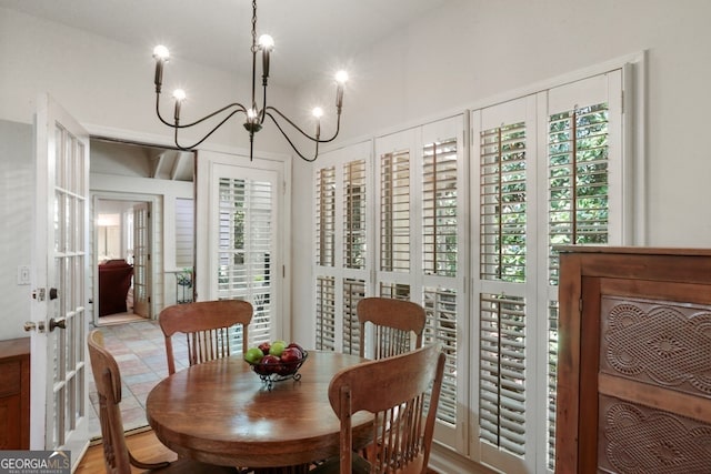 dining room with a notable chandelier, light wood-type flooring, a healthy amount of sunlight, and french doors