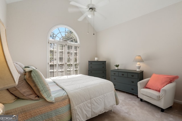 carpeted bedroom featuring high vaulted ceiling and ceiling fan