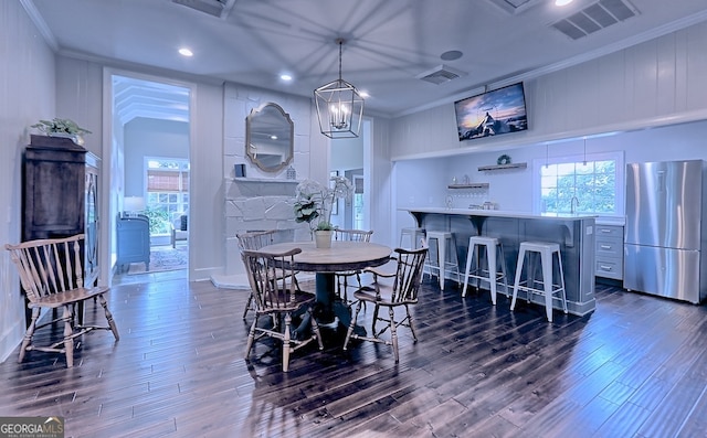 dining room featuring ornamental molding, a notable chandelier, and dark hardwood / wood-style flooring