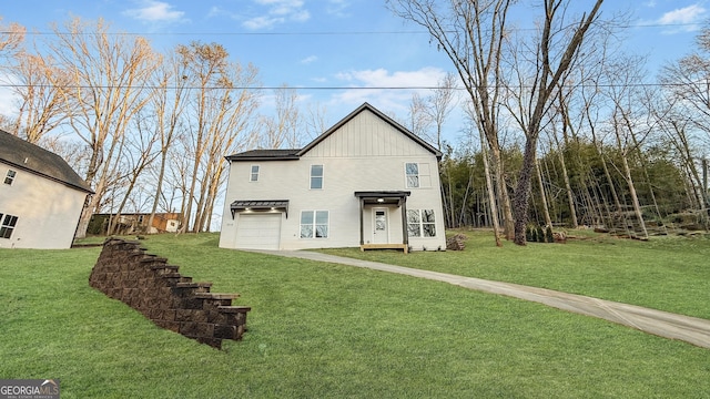 view of front of home featuring a garage, driveway, board and batten siding, and a front lawn