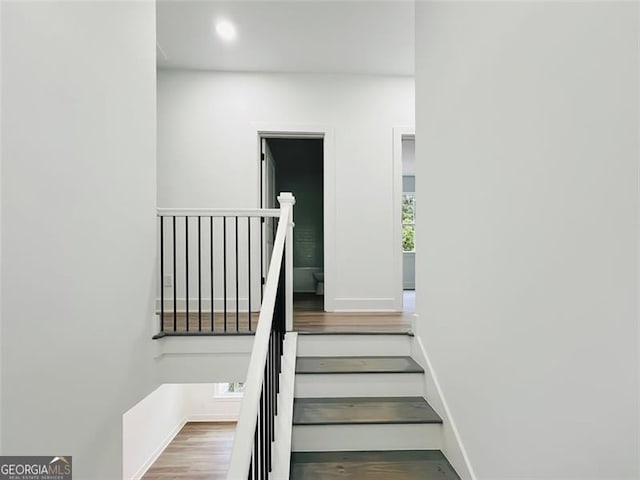 stairs featuring recessed lighting, wood finished floors, and baseboards