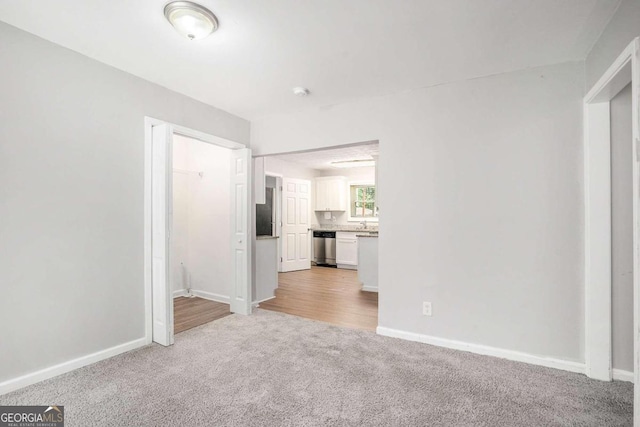 unfurnished living room featuring baseboards and carpet floors