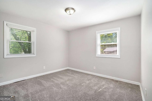 carpeted empty room with baseboards
