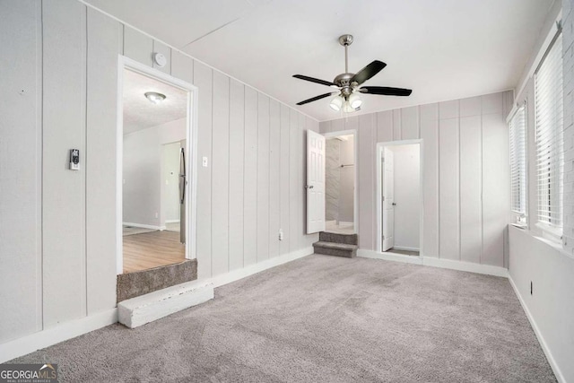 unfurnished bedroom featuring baseboards, a ceiling fan, and carpet