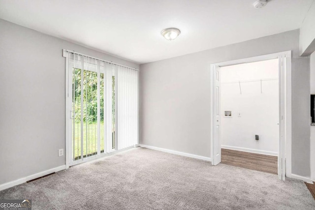 spare room featuring baseboards and carpet flooring