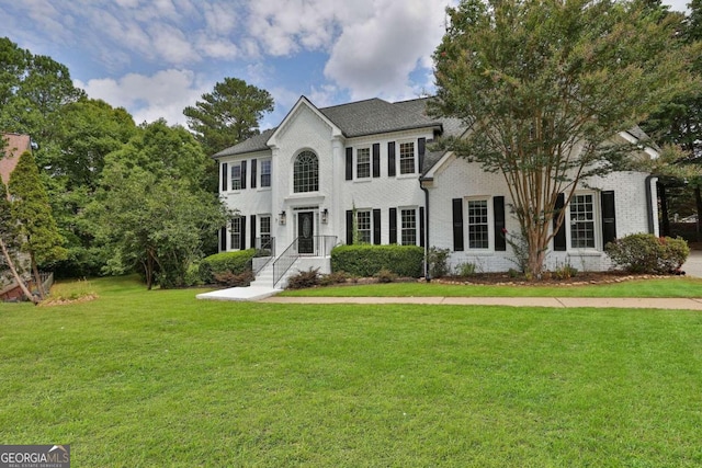 colonial house featuring a front lawn