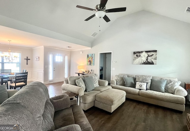 living room featuring vaulted ceiling, dark hardwood / wood-style floors, ceiling fan with notable chandelier, and crown molding