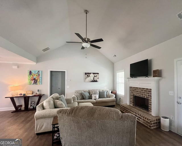 living room featuring dark wood-type flooring, ceiling fan, a fireplace, and vaulted ceiling