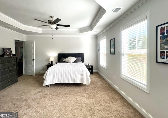 bedroom with ornamental molding, light colored carpet, a raised ceiling, and ceiling fan