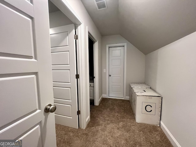 corridor with carpet flooring and vaulted ceiling