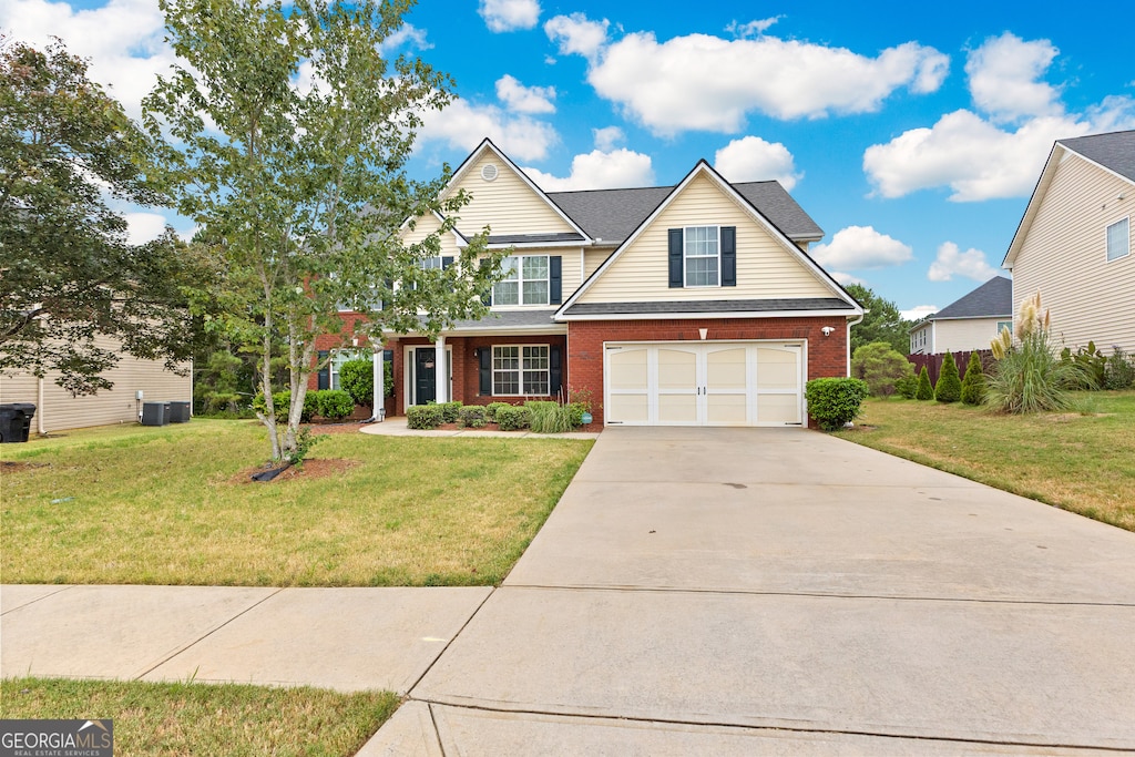 view of front of house with a front yard, a garage, and central AC