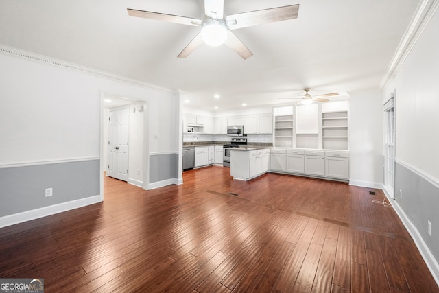 unfurnished living room featuring ceiling fan, dark hardwood / wood-style floors, and ornamental molding