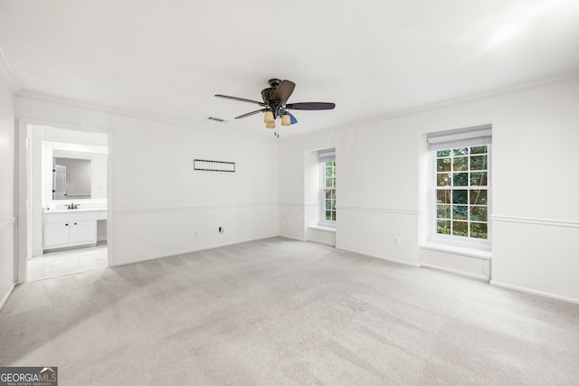 unfurnished room with crown molding, ceiling fan, light carpet, and sink