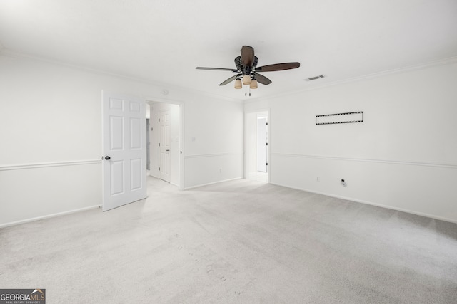 unfurnished room featuring ceiling fan, light colored carpet, and crown molding