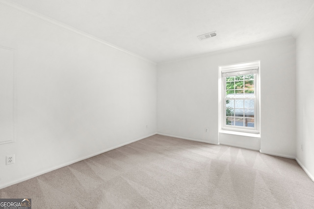 empty room featuring crown molding and light colored carpet