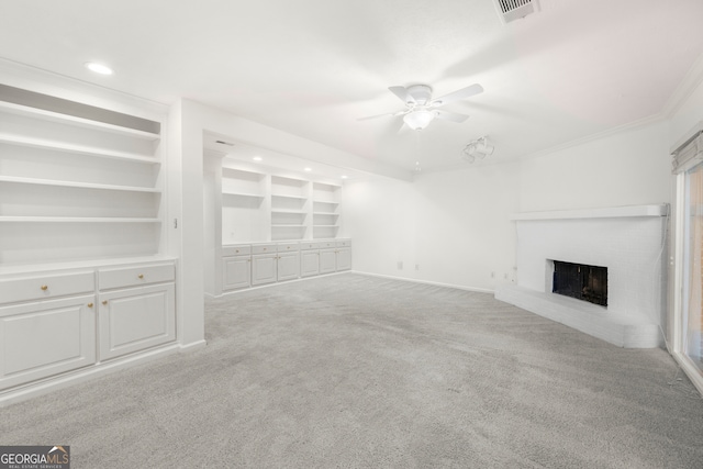 unfurnished living room with ceiling fan, built in features, light carpet, a fireplace, and crown molding