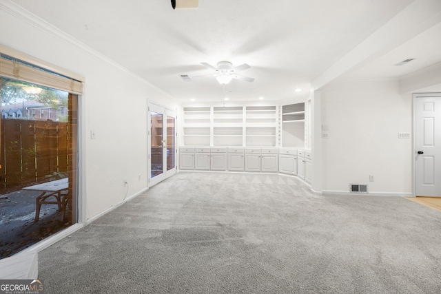 unfurnished living room featuring ornamental molding, ceiling fan, and light carpet