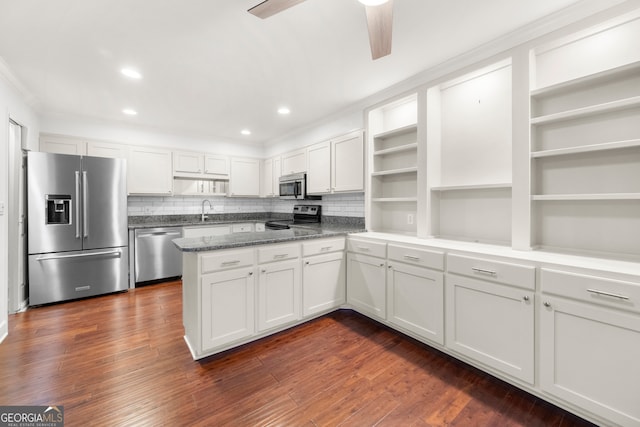 kitchen featuring stainless steel appliances, white cabinets, dark hardwood / wood-style floors, and tasteful backsplash