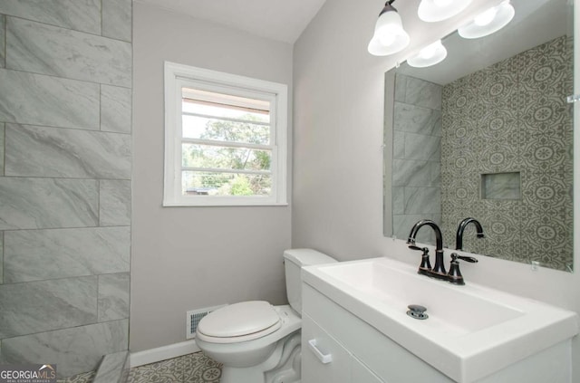 bathroom with tile patterned flooring, vanity, and toilet