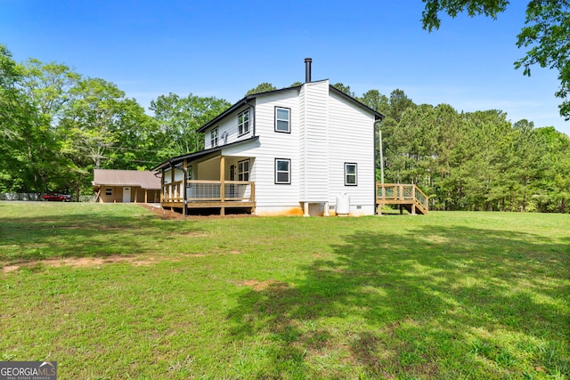 rear view of house featuring crawl space, a deck, and a lawn