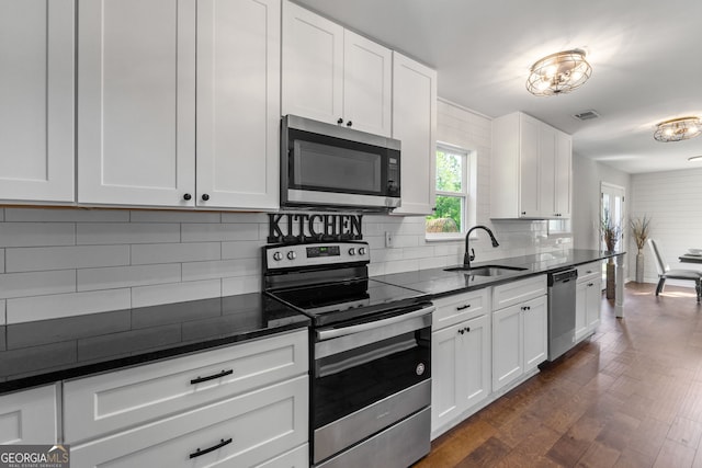 kitchen featuring tasteful backsplash, visible vents, appliances with stainless steel finishes, white cabinetry, and a sink