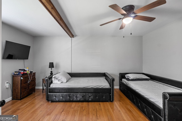 bedroom featuring light wood-style flooring, baseboards, ceiling fan, and beam ceiling