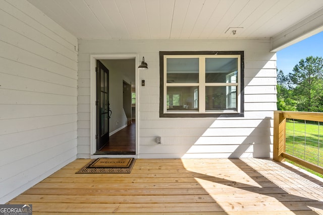 view of exterior entry featuring a wooden deck