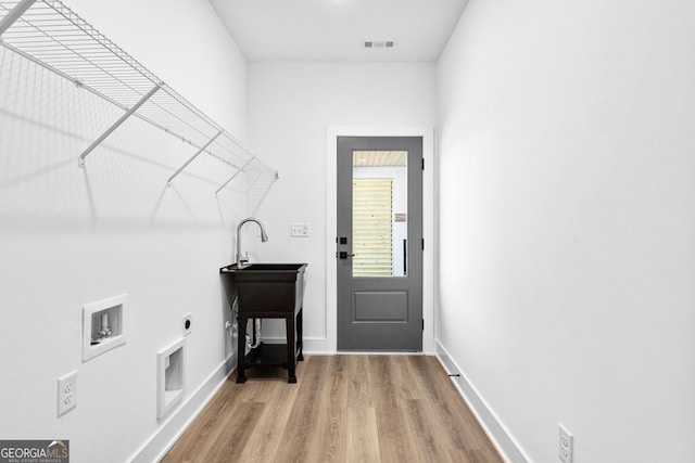 washroom with washer hookup, visible vents, light wood-style floors, electric dryer hookup, and laundry area