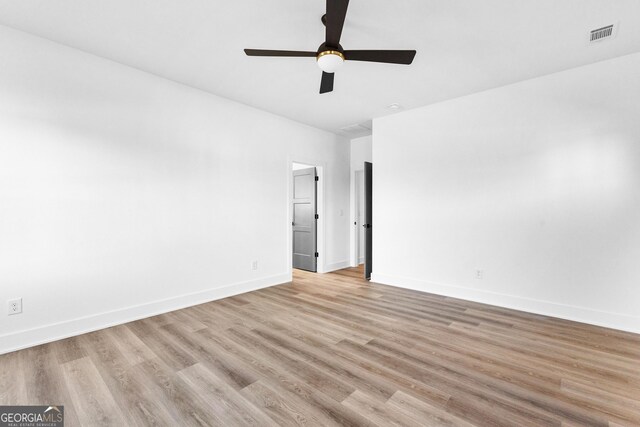 unfurnished room with ceiling fan and a barn door